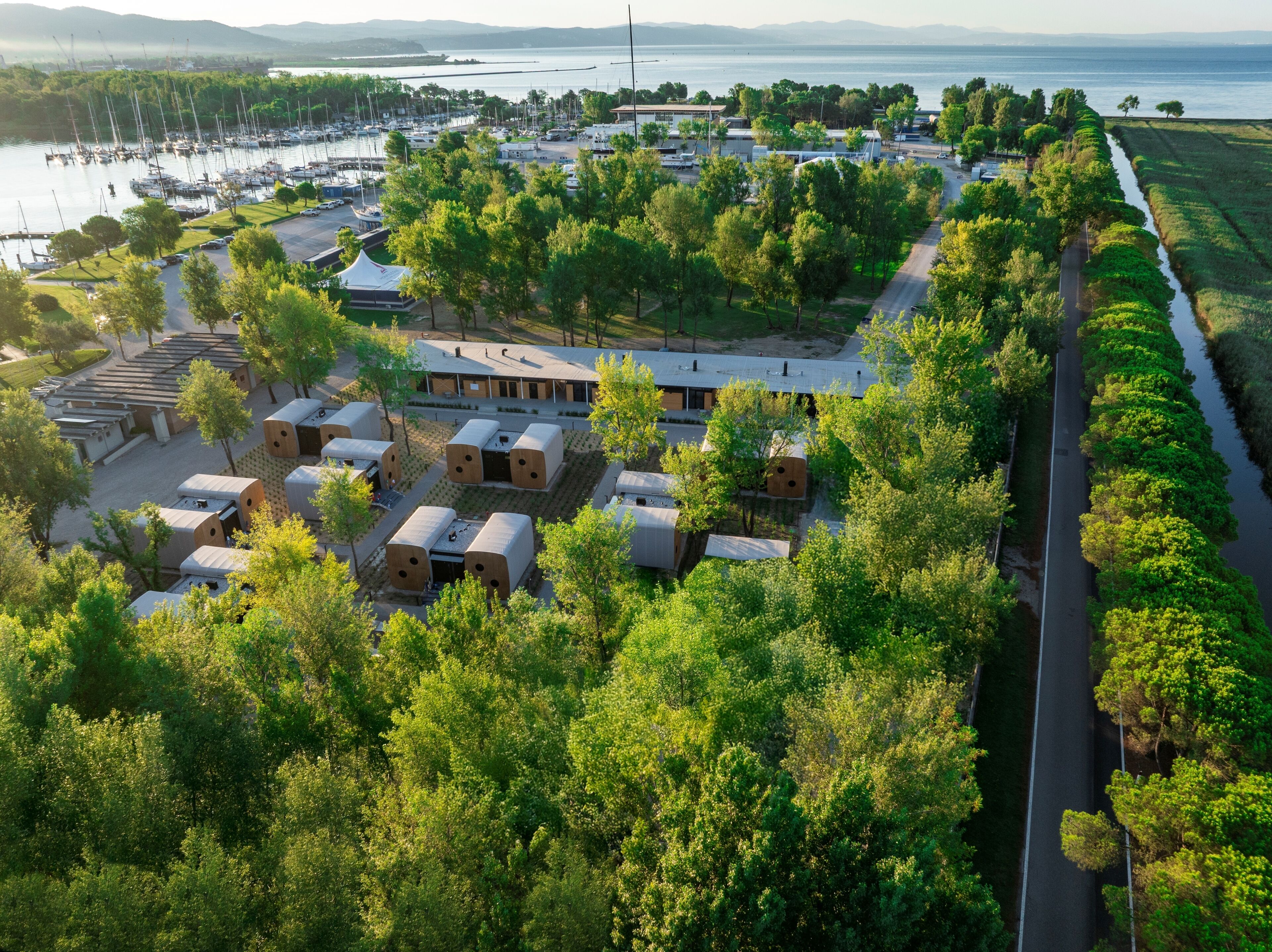 A marina with boats, a road, and a building with multiple rooms.