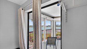 Varanda com vista para um lago, uma cadeira e uma mesa.