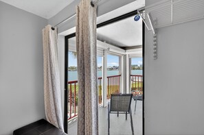 A balcony with a view of a lake, a chair, and a table. - 2BR 2Ba Treasure Island Luxury waterfront updated Condo., steps to beach access (Treasure Island)