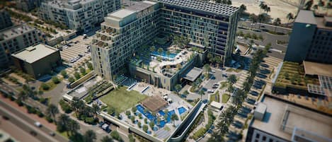 A modern building complex with multiple floors, a central courtyard, and surrounding greenery.