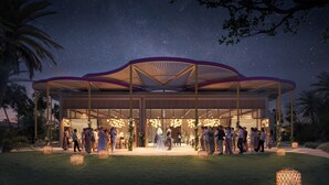 Um pavilhão ao ar livre sob um céu estrelado, rodeado por convidados.