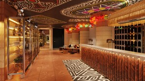 A hallway with a patterned floor, a reception desk with a wooden backdrop, and a decorative ceiling with geometric designs. - Mama Shelter Cape Town (CAPE TOWN)