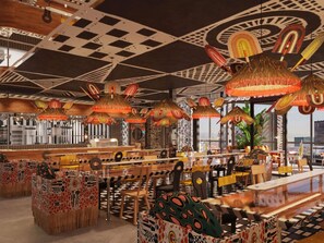 A restaurant with a checkered ceiling, hanging woven lamps, and patterned furniture. - Mama Shelter Cape Town (CAPE TOWN)