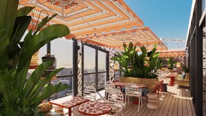 A rooftop terrace with outdoor seating, large potted plants, and a patterned ceiling. - Mama Shelter Cape Town (CAPE TOWN)