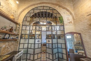 Un interior rústico con paredes de ladrillo visto, techo de madera y un separador decorativo de metal.