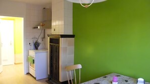Eine kleine Küche mit Kühlschrank, Spüle und einem Essbereich mit Tisch.