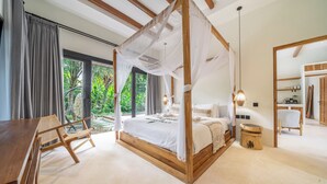 A bedroom with a four-poster bed, a wooden desk, a chair, and a small stool. - Hutan Villa - Open Bath and Private Pool (Ubud)