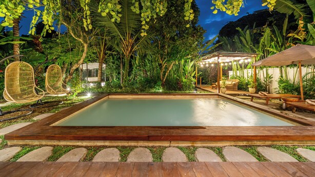 A pool with a wooden deck, surrounded by lush greenery and a wooden pergola. - Hutan Villa - Open Bath and Private Pool (Ubud)