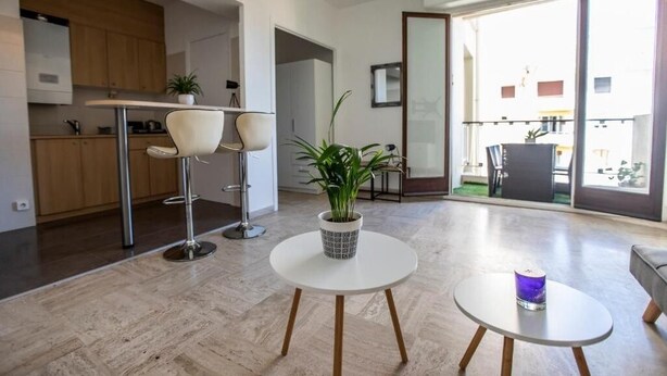 Ein modernes Interieur mit Küche, Essbereich und einem Balkon mit Blick.