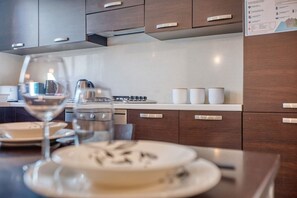 Eine moderne Küche mit Holzausstattung, einem Gasherd und weißen Arbeitsplatten.