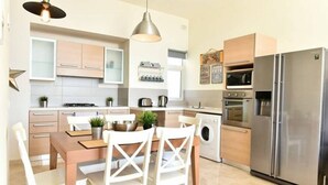 Una cocina moderna con comedor, electrodomésticos de acero inoxidable y lavadora.