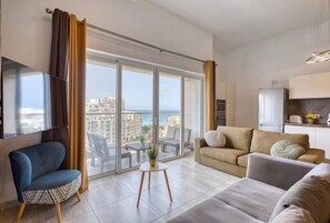 Ein modernes Wohnzimmer mit einer Couch, einem Sessel und einem kleinen Tisch mit einer Pflanze.
