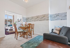 En moderne stue med spiseområde, sofa og pejs.