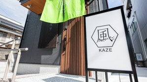 A hotel entrance with a wooden door, a green banner, and a signboard with the hotel's logo. - Irodori Hotel KAZE (fukuokashi,hakataku,toukou)