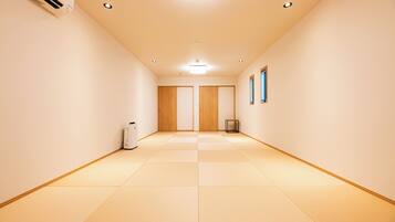 A hallway with tatami mats, a ceiling light, and a framed picture on the wall.