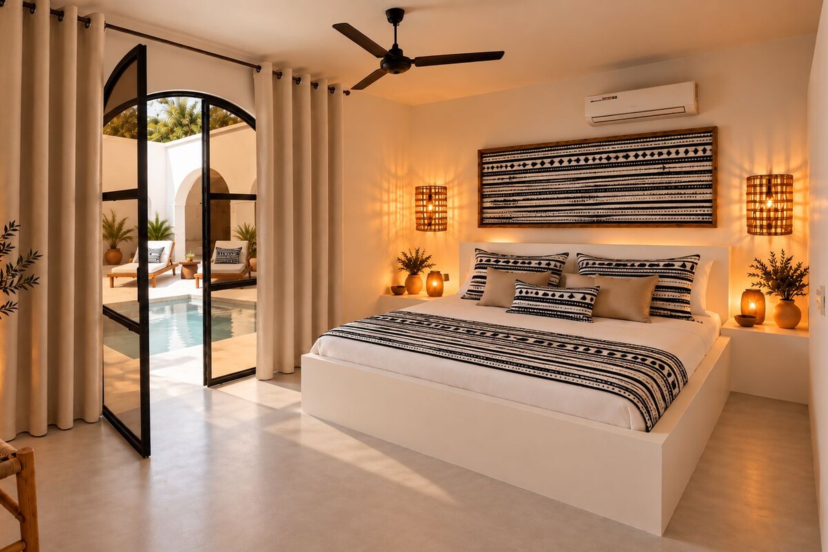 A modern bedroom with a large bed, a ceiling fan, and a view of a pool through a glass door.
