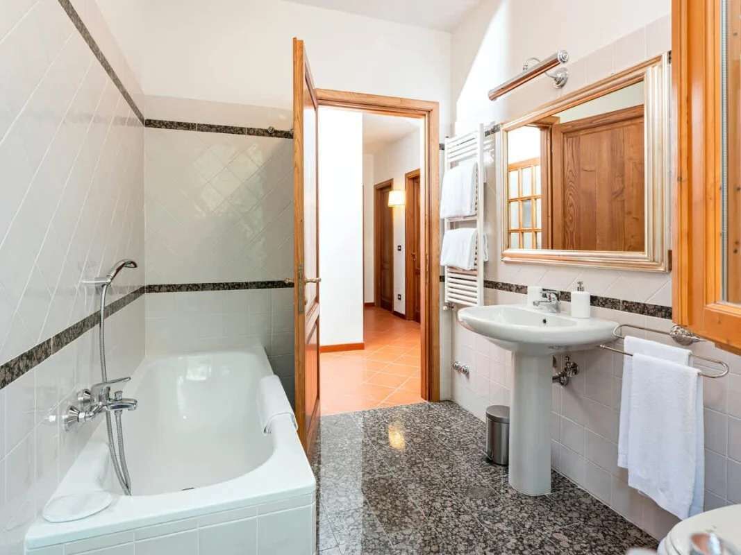 Een badkamer met een bad, wastafel en spiegel.