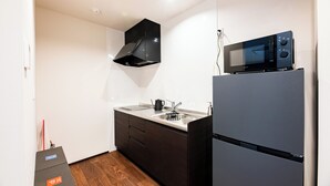 Una cocina compacta con microondas, estufa y lavabo.