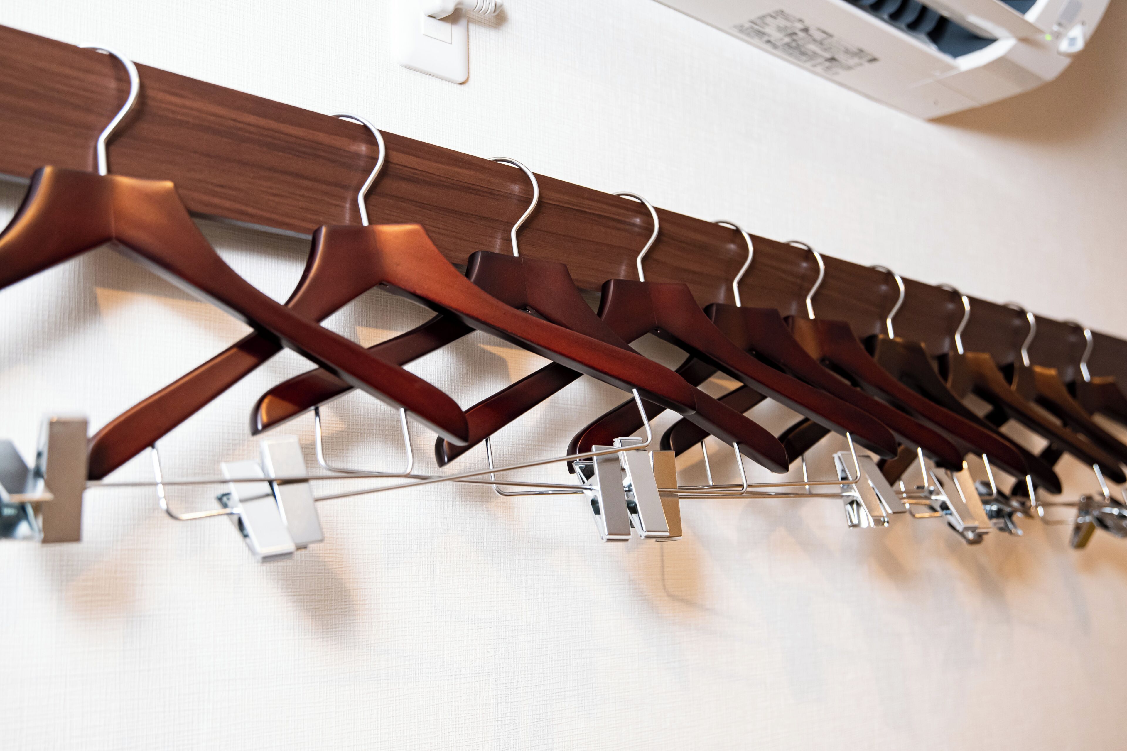 A row of wooden coat hooks on a wall.