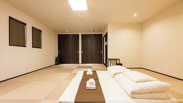 A hotel room with a bed, a small table, and a wardrobe.