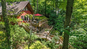 Een chalet met een houten terras en een trap naar een hoger niveau.
