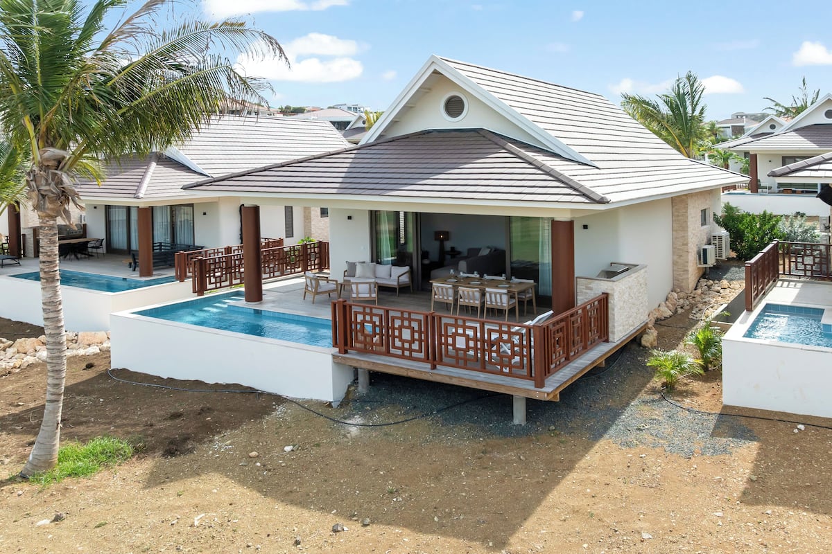 A resort with a pool, outdoor seating, and a covered patio.
