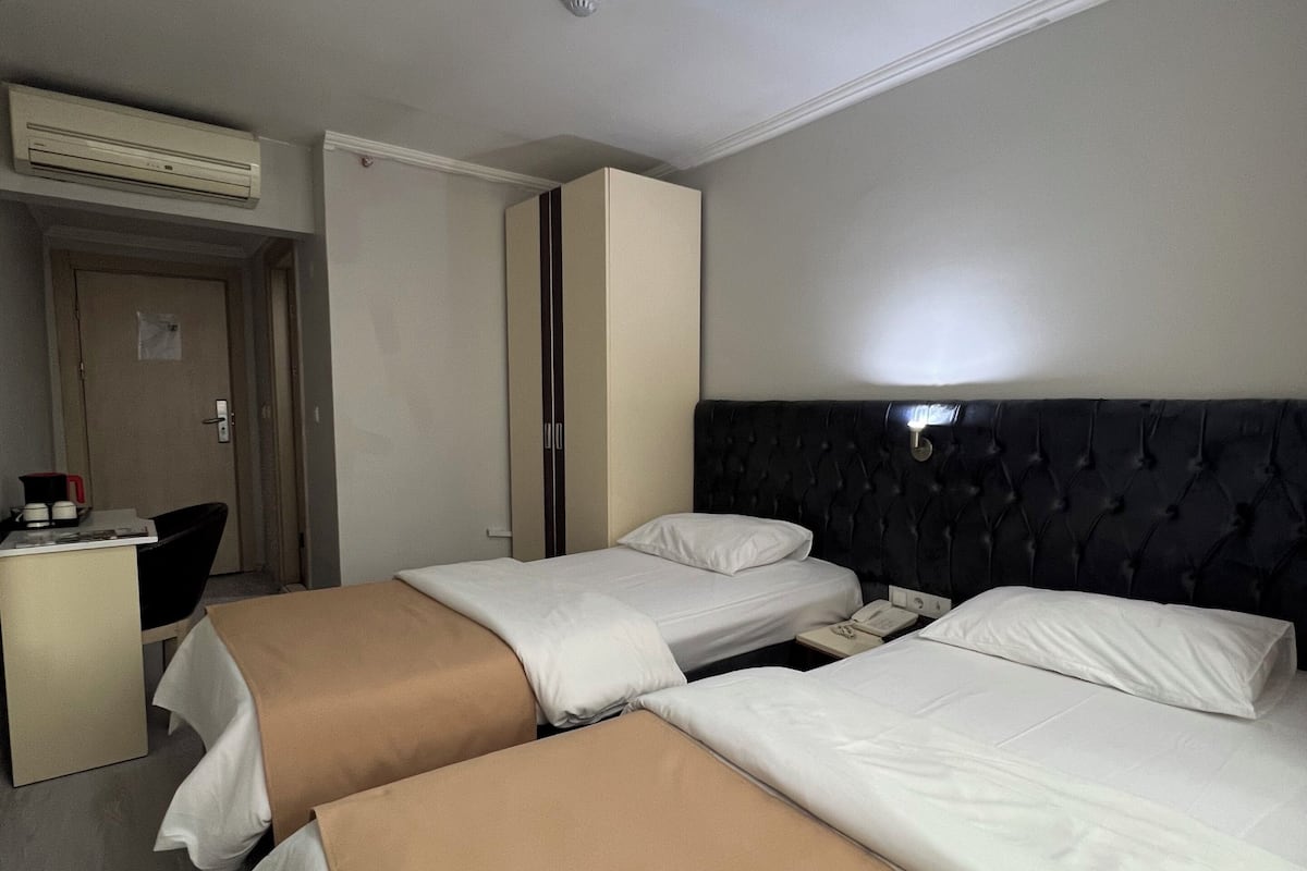 Una habitación de hotel con dos camas, un escritorio y un armario.