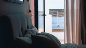 A room with a bed, a window, and a view of the sea. - Experience a brand-new seafront duplex penthouse in Ghadira Bay, featuring 2 bedrooms, 2 bathrooms, a fully equipped kitchen and two spacious terraces, both offering beautiful sea views just steps from the beach. (Il-Mellieħa)