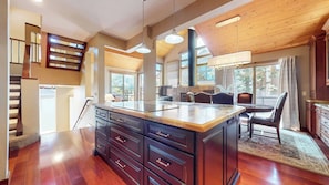 A spacious kitchen with a large island, wooden flooring, and a view of the outdoors. - Private Garage & Laundry, Views of Mammoth Rock, Welcomes Pets (Mammoth Lakes)