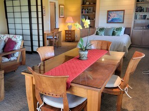 Ein traditioneller japanischer Raum mit Tatami-Boden, einem niedrigen Holztisch und einem Futon.
