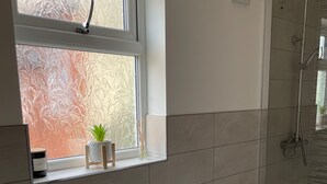 Ein Badezimmer mit Badewanne, Toilette und einem Fenster mit Milchglas.