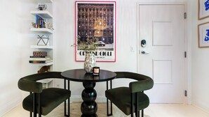 A dining area with a round table, two chairs, a vase, and a framed picture on the wall. - World Cup | .4 Mi to Ponce | 3 Mi to Mercedes Benz (Atlanta)