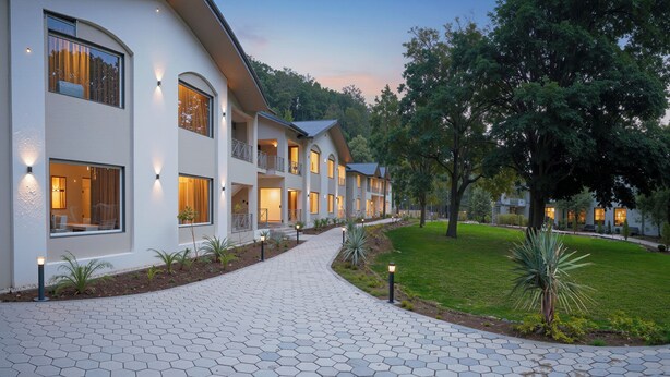 A modern hotel with a hexagonal tile pathway leading to the entrance. - Vanasya Retreat Corbett (Ramnagar)