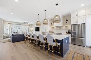 A modern kitchen with a central island, stainless steel appliances, and pendant lighting. - Just Baskin- Walking Distance-Downtown Morehead City (Morehead City)