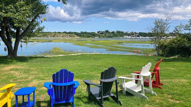Outdoor seating with Adirondack chairs and a table, a tree, and a lake view. - Lovely 'the Buoys Cottage' on Annisquam River! (Gloucester)