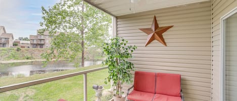 A covered balcony with a red chair, a star decoration, and a potted plant.