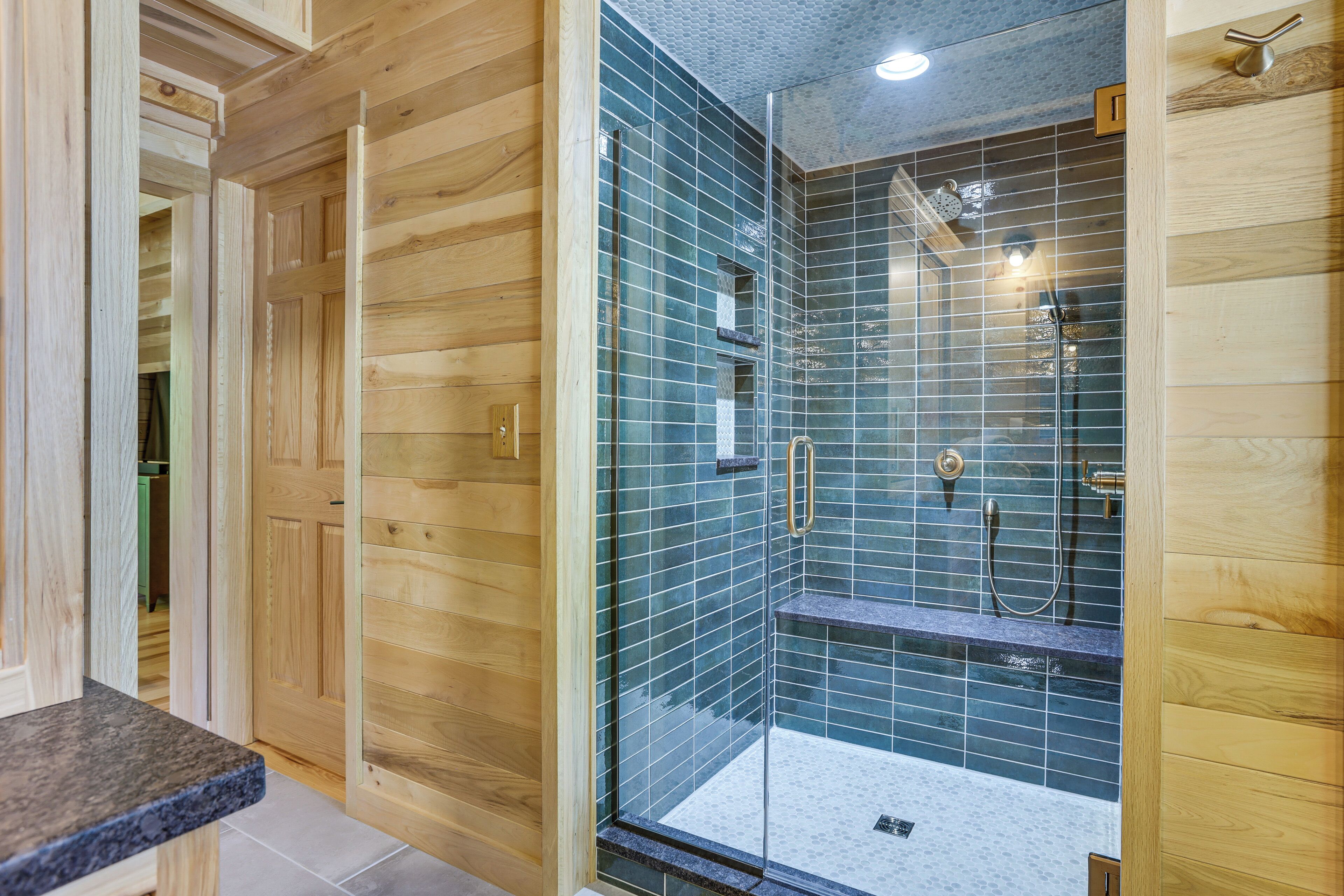 Interior de madera con zona de ducha acristalada.