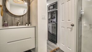 Une salle de bain avec un miroir, un lavabo et un espace douche.