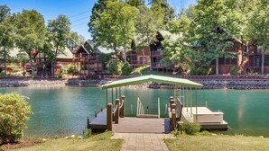 A lakeside lodge with a dock, a covered seating area, and a stone pathway leading to the dock. - Game Room, Dock & More! Panoramic Lakefront Oasis (Six Mile)