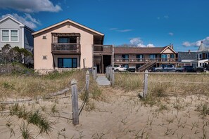 A beachfront property with a two-story building, a covered walkway, and a parking area. - Beachfront Condotel on Oob, Steps From Downtown (Old Orchard Beach)