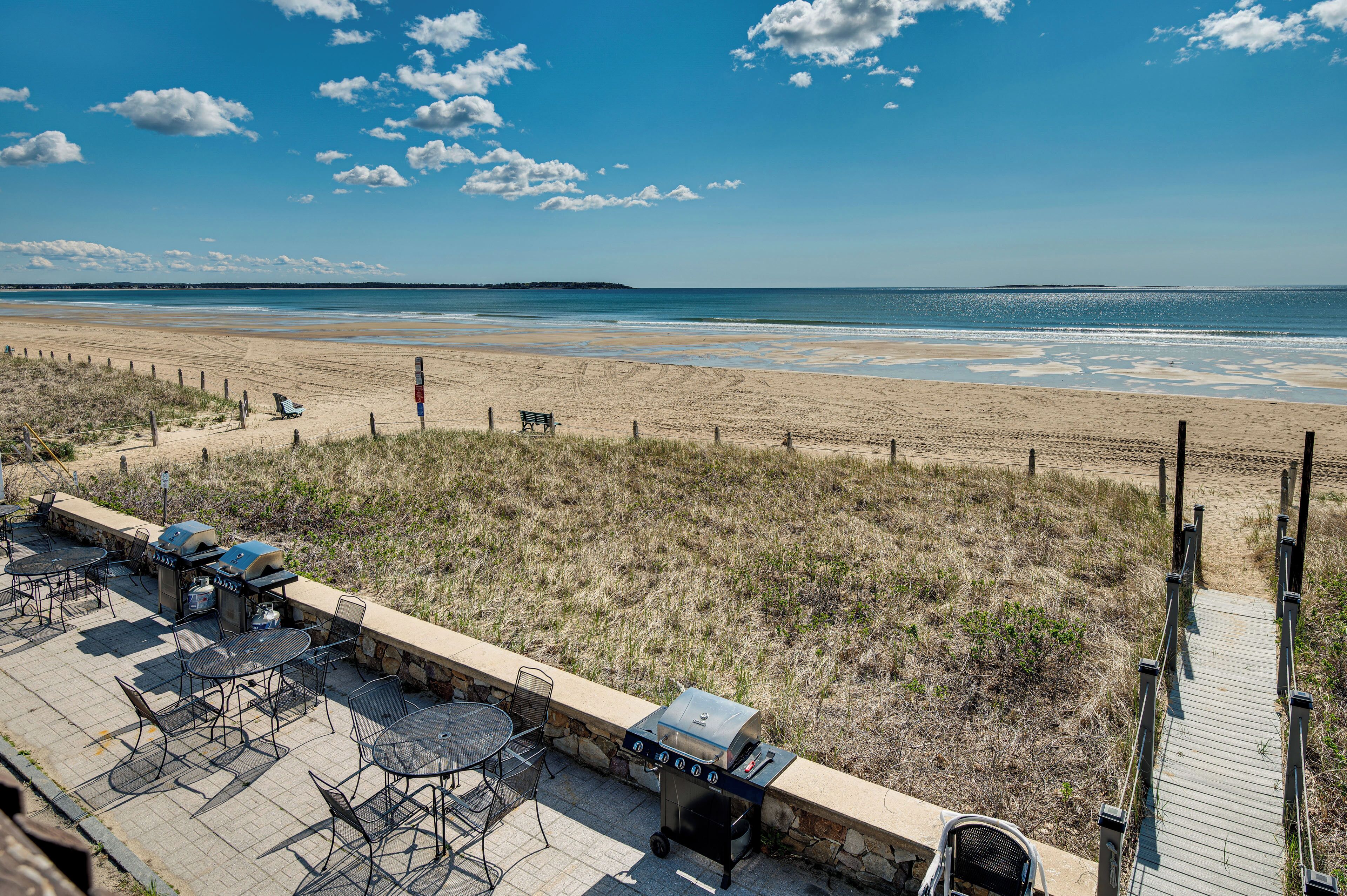 Eine Terrassenausstattung am Strand mit Sitzgelegenheiten im Freien, einem Grill und Blick auf den Ozean.