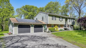 A two-story house with a garage, solar panels, and a well-maintained lawn. - Trailside Escape! Cozy Stormville Apartment (Stormville)
