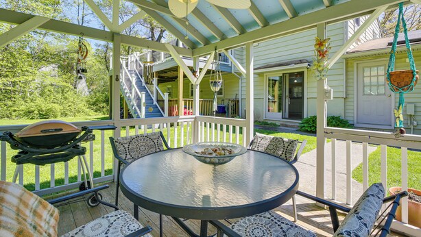 A covered outdoor patio with a round table, chairs, and a grill. - Trailside Escape! Cozy Stormville Apartment (Stormville)
