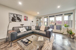 Ein modernes Wohnzimmer mit einer Eckcouch, einem Couchtisch und Kunstwerken an den Wänden.