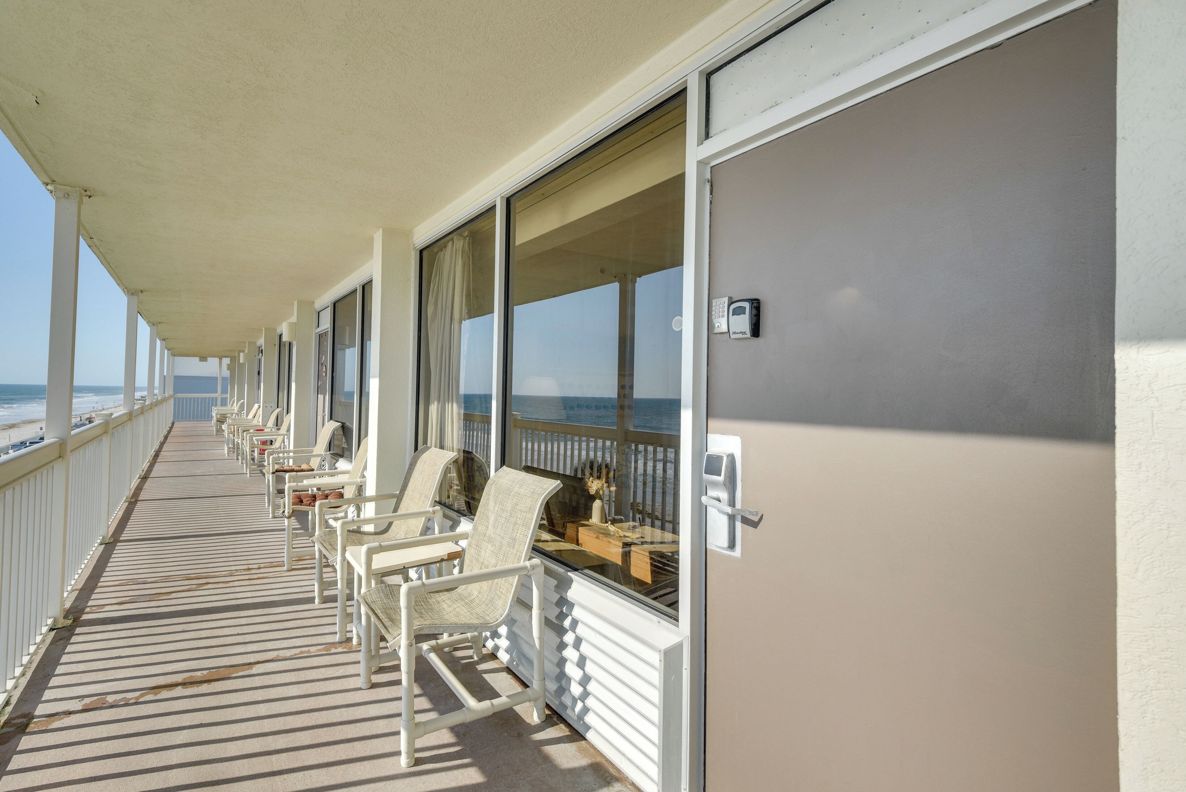 Un balcon avec des chaises et une table, donnant sur l’océan.