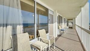 Ein Balkon mit Stühlen und Blick auf das Meer.