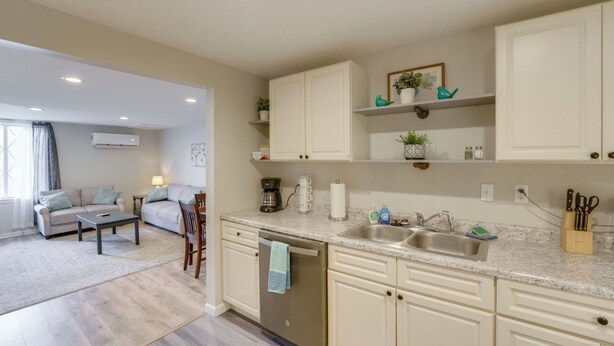 A modern kitchen with white cabinets, a dishwasher, and a countertop with a sink. - Creekside Picnic Area! Stay Near Blue Water Bridge (Port Huron)