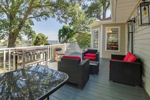 Une terrasse dotée de mobilier d’extérieur, d’un barbecue et offrant une vue sur l’eau.