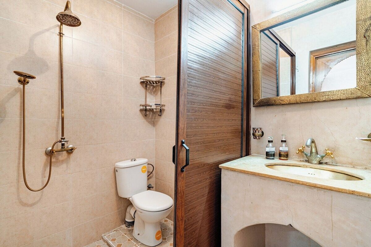 A bathroom with a toilet, bidet, and shower.