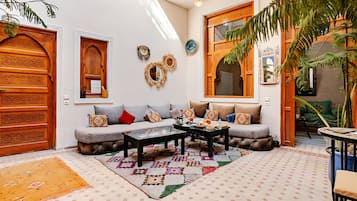 Un salon chaleureux avec un canapé, une table basse et des tapis décoratifs.